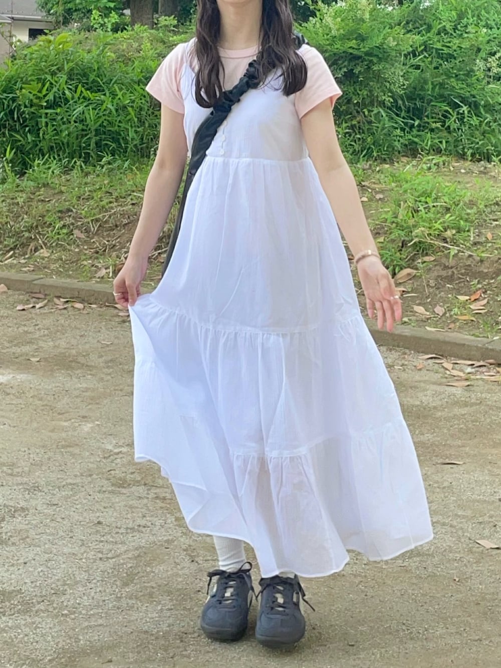 ホワイト系のワンピース、ピンク系のTシャツ/カットソー、グレー系のスニーカーを着用したレディースの春コーディネートの2枚目の写真