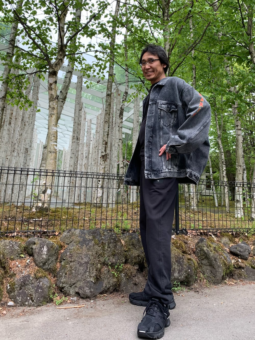 ブラック系のスウェットパンツ、ブラック系のデニムジャケット、ブラック系のスニーカーを着用したメンズの春コーディネートの2枚目の写真