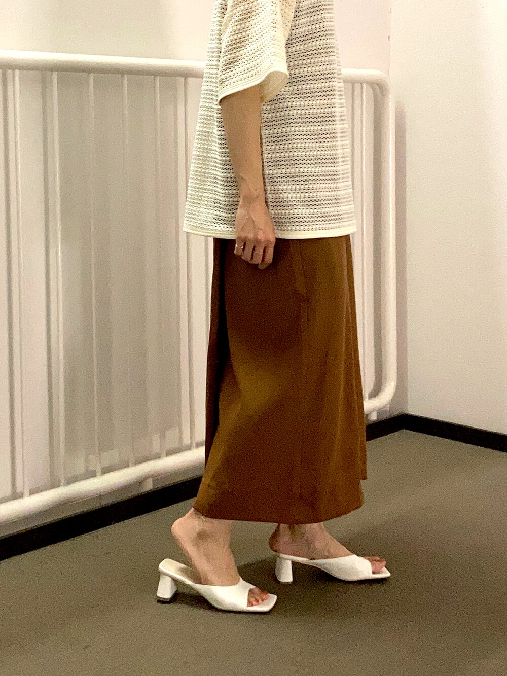 ホワイト系のシャツ/ブラウス、ブラウン系のワンピース、ホワイト系のサンダルを着用したレディースの春コーディネートの2枚目の写真