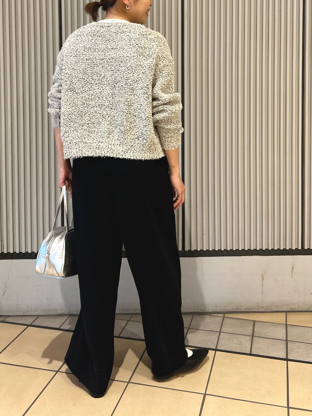 ブラック系のサロペット/オーバーオール、ホワイト系のカーディガン/ボレロ、シルバー系のボストンバッグを着用したレディースの冬コーディネートの3枚目の写真