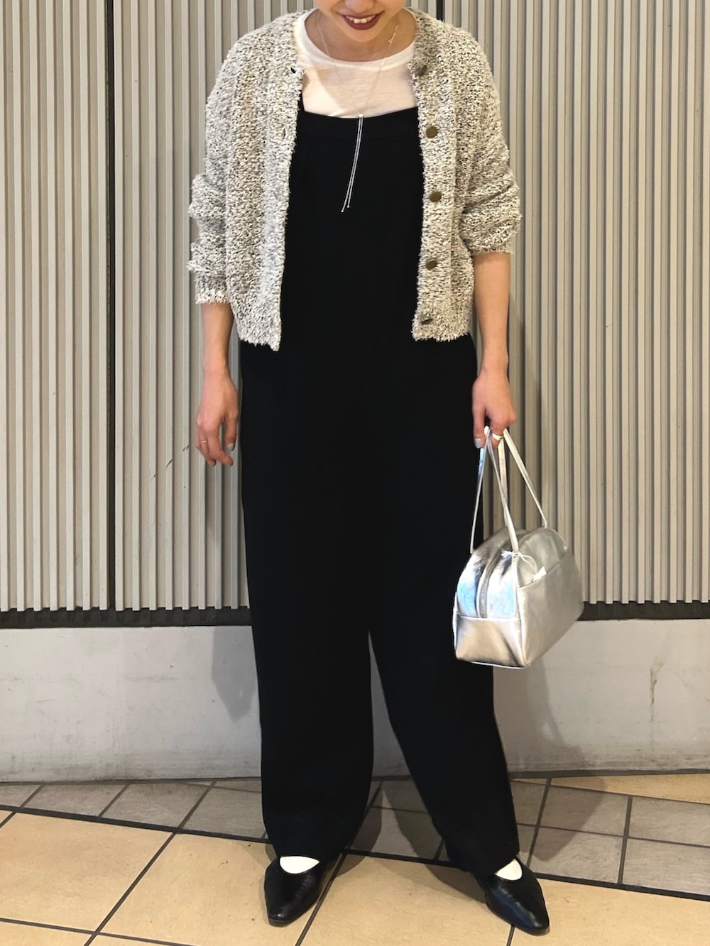 ブラック系のサロペット/オーバーオール、ホワイト系のカーディガン/ボレロ、シルバー系のボストンバッグを着用したレディースの冬コーディネートの4枚目の写真