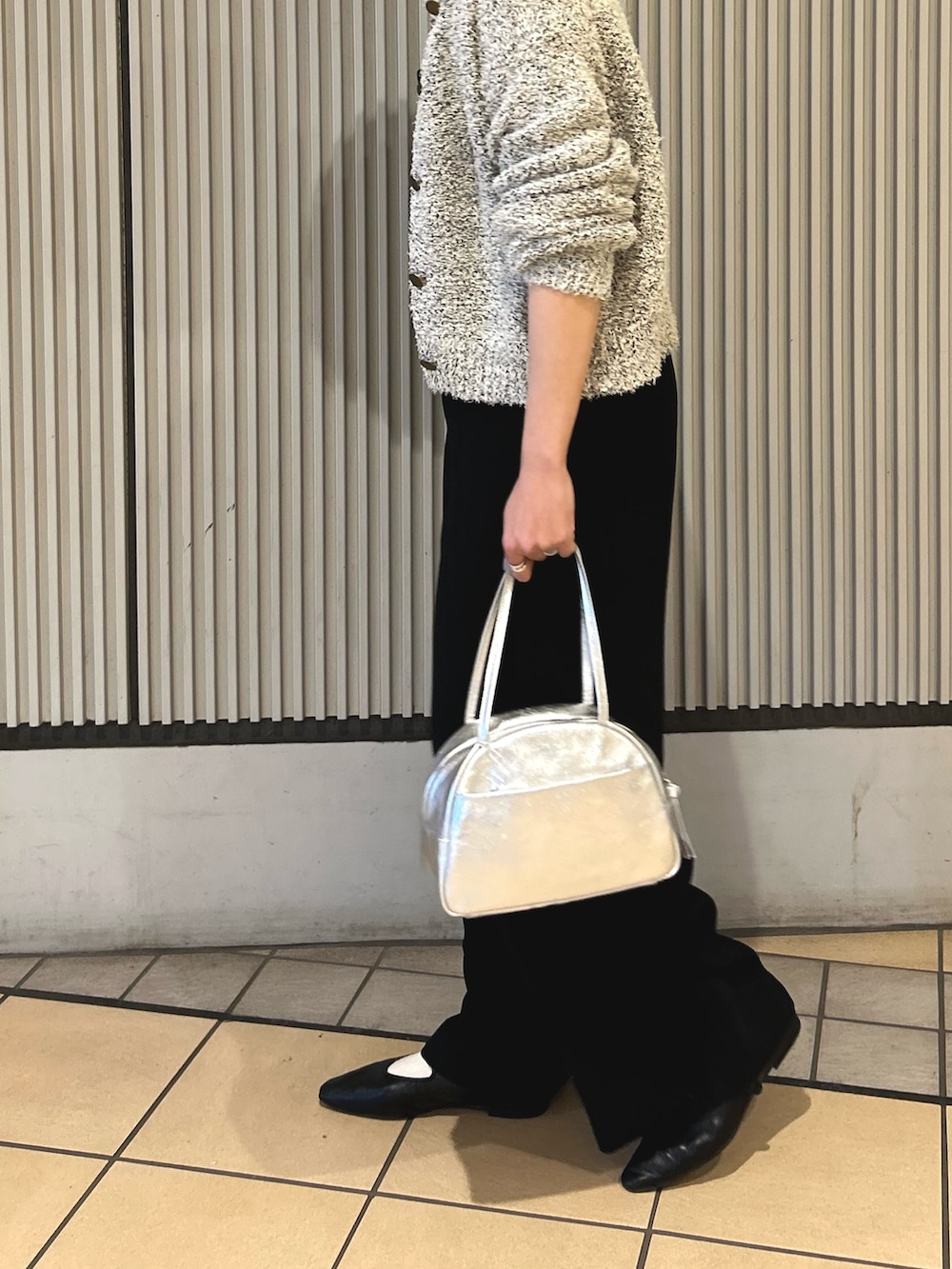 ブラック系のサロペット/オーバーオール、ホワイト系のカーディガン/ボレロ、シルバー系のボストンバッグを着用したレディースの冬コーディネートの2枚目の写真