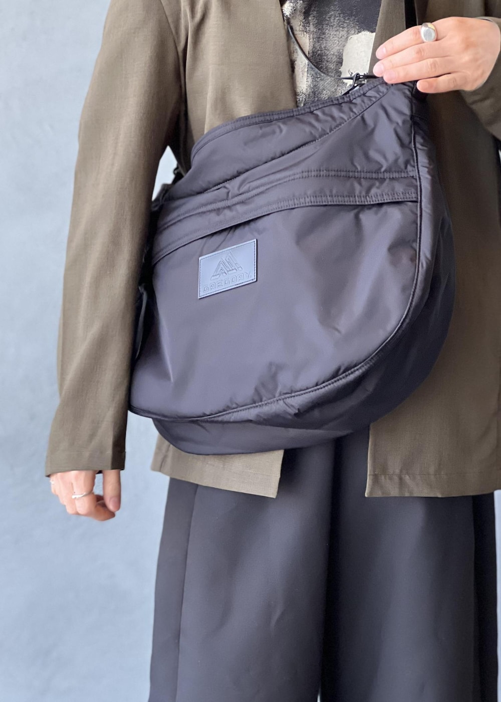 ブラック系のショルダーバッグ、グリーン系のセットアップ、ブラック系のその他パンツを着用したメンズの春コーディネートの7枚目の写真