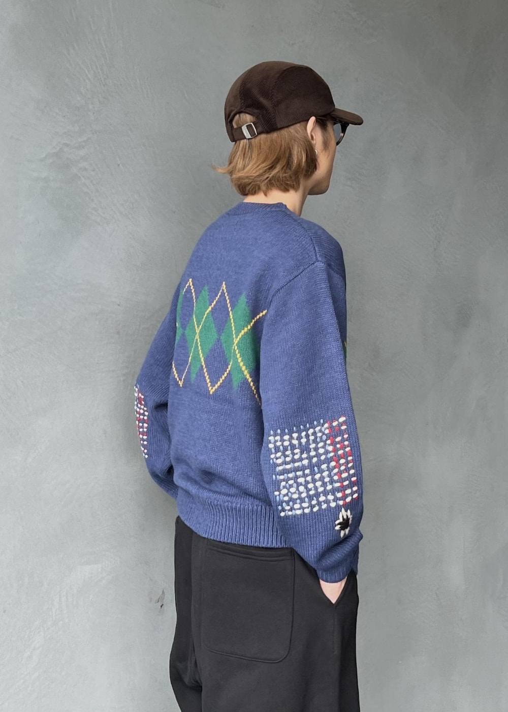 ブラック系のその他パンツ、ブルー系のカーディガン/ボレロ、ブラウン系のキャップを着用したメンズの秋コーディネートの4枚目の写真