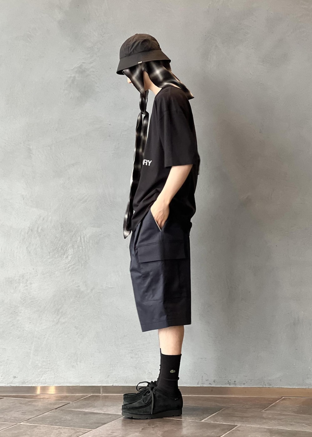 ブルー系のスラックス、ブラック系のTシャツ/カットソー、ブラック系のサングラスを着用したメンズの夏コーディネートの2枚目の写真