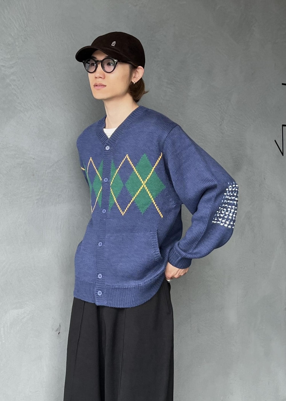 ブラック系のその他パンツ、ブルー系のカーディガン/ボレロ、ブラウン系のキャップを着用したメンズの秋コーディネートの3枚目の写真