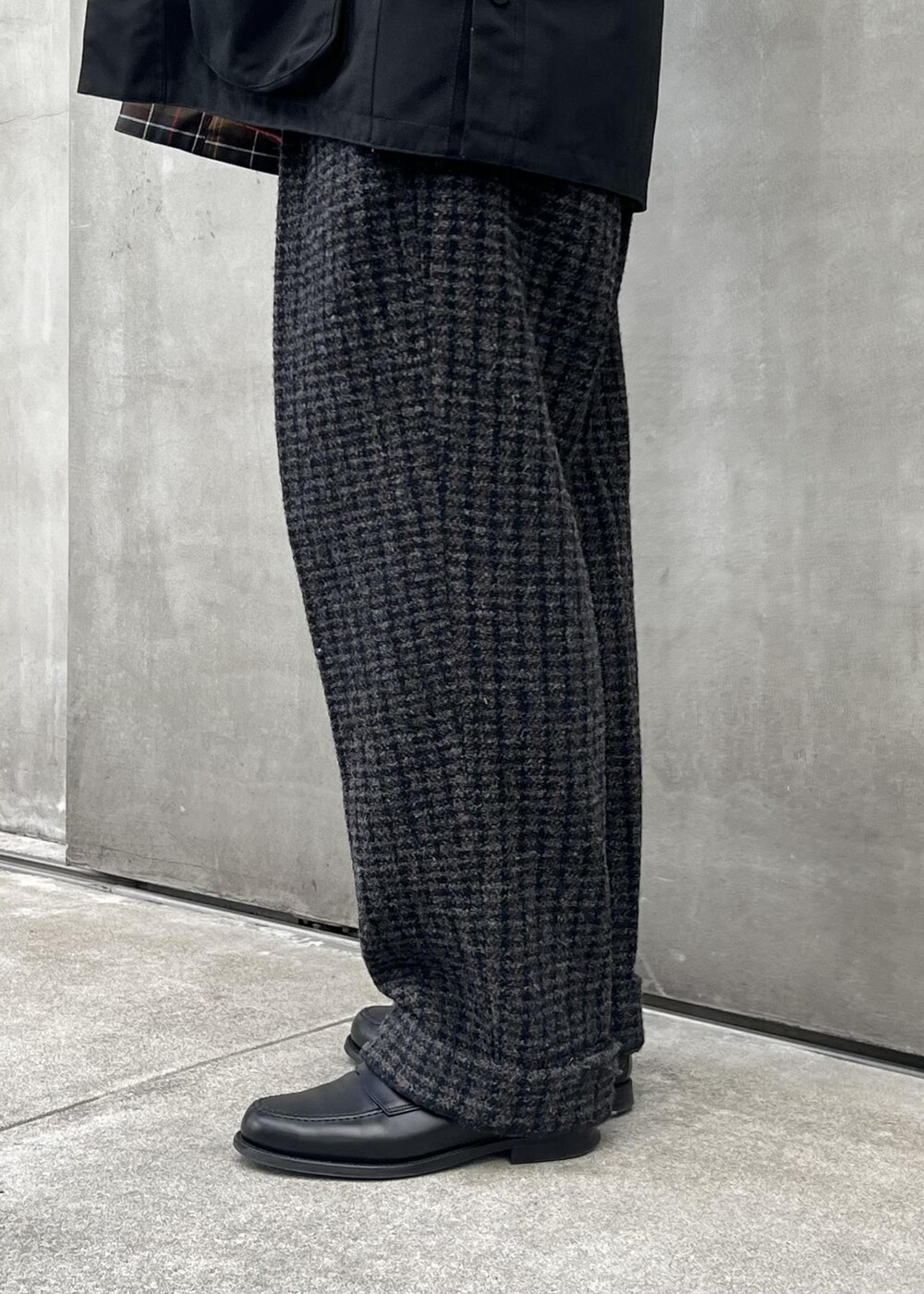 ブラック系のブルゾン、グレー系のスラックスを着用したメンズの冬コーディネートの4枚目の写真