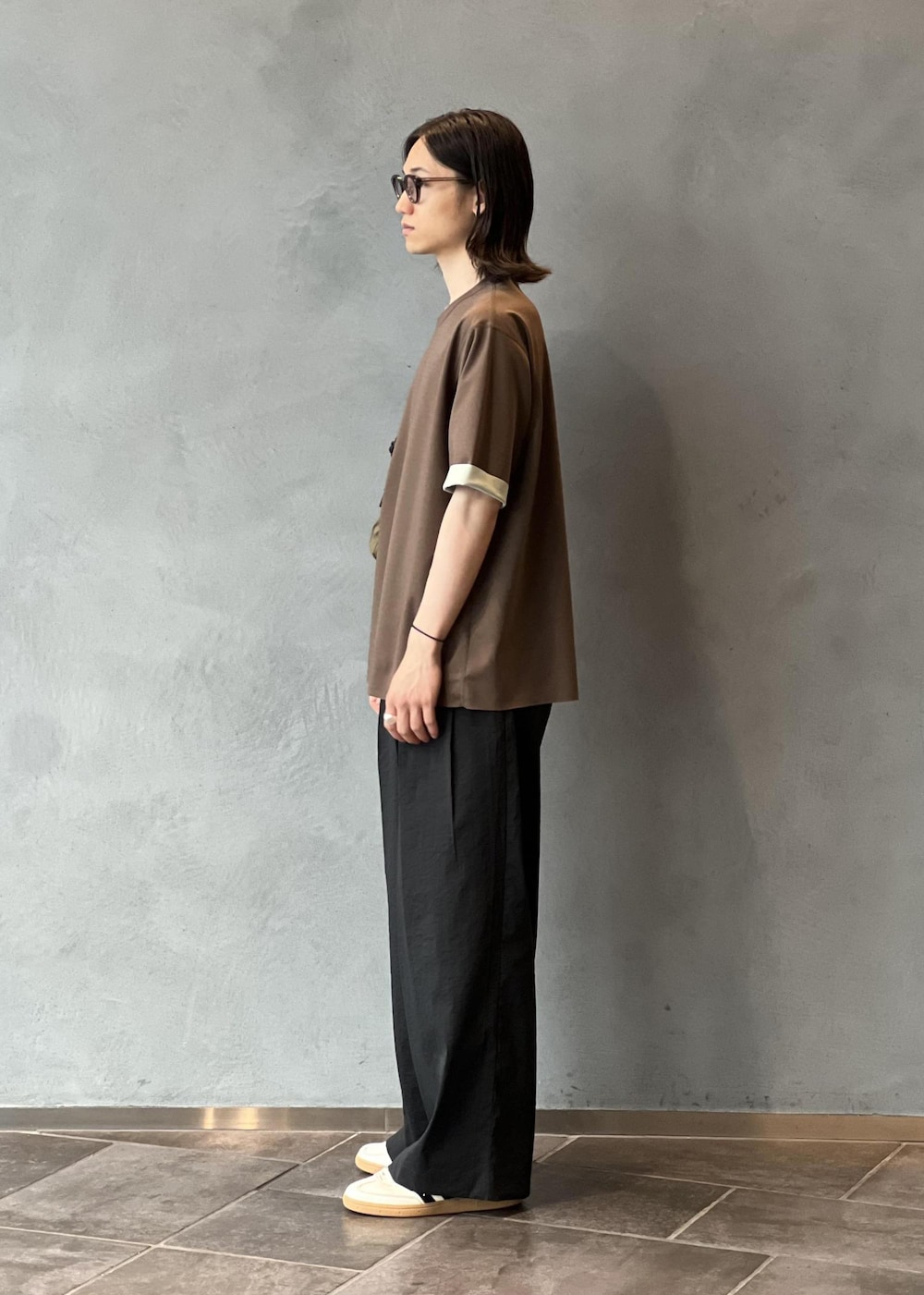 ブラック系のその他パンツ、ホワイト系のスニーカー、ブラウン系のTシャツ/カットソーを着用したメンズの夏コーディネートの2枚目の写真