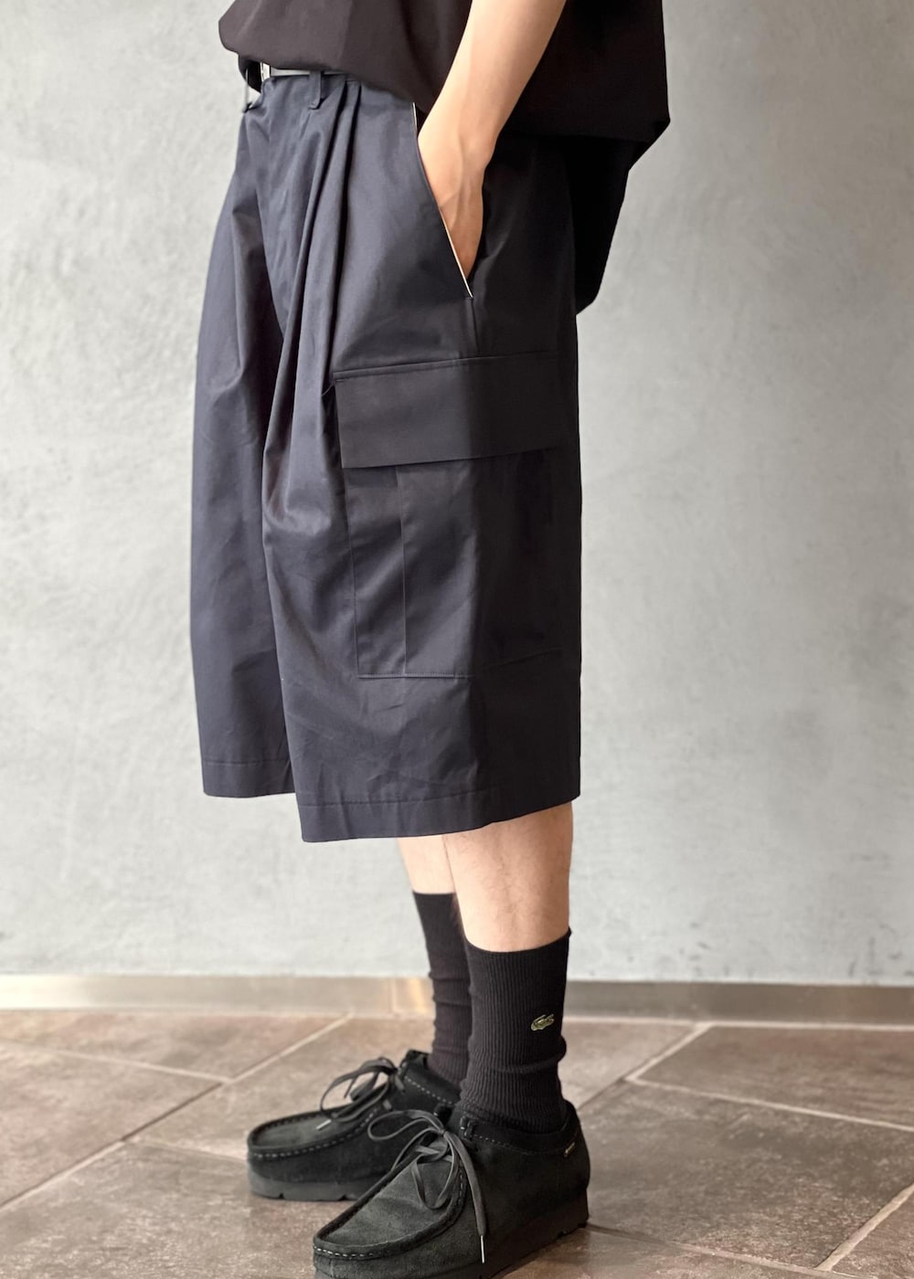 ブルー系のスラックス、ブラック系のTシャツ/カットソー、ブラック系のサングラスを着用したメンズの夏コーディネートの6枚目の写真