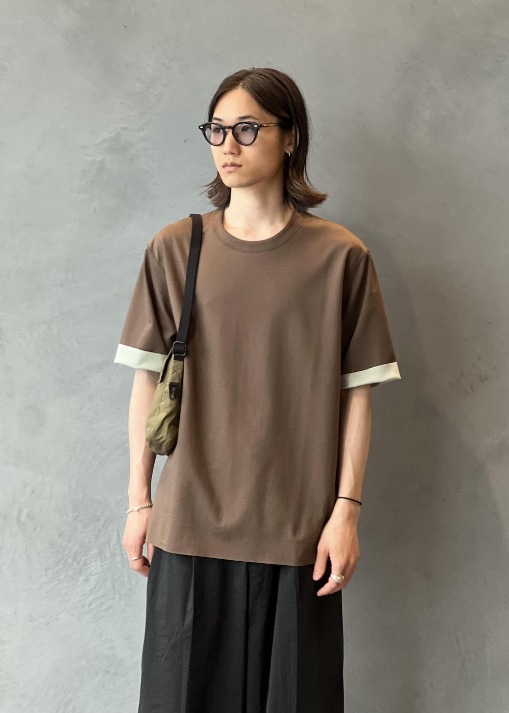 ブラック系のその他パンツ、ホワイト系のスニーカー、ブラウン系のTシャツ/カットソーを着用したメンズの夏コーディネートの3枚目の写真