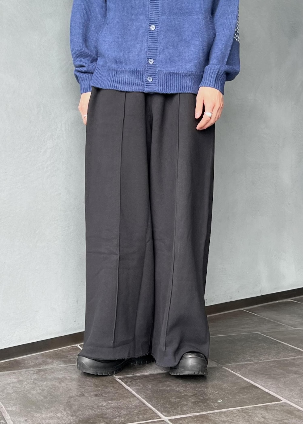 ブラック系のその他パンツ、ブルー系のカーディガン/ボレロ、ブラウン系のキャップを着用したメンズの秋コーディネートの5枚目の写真