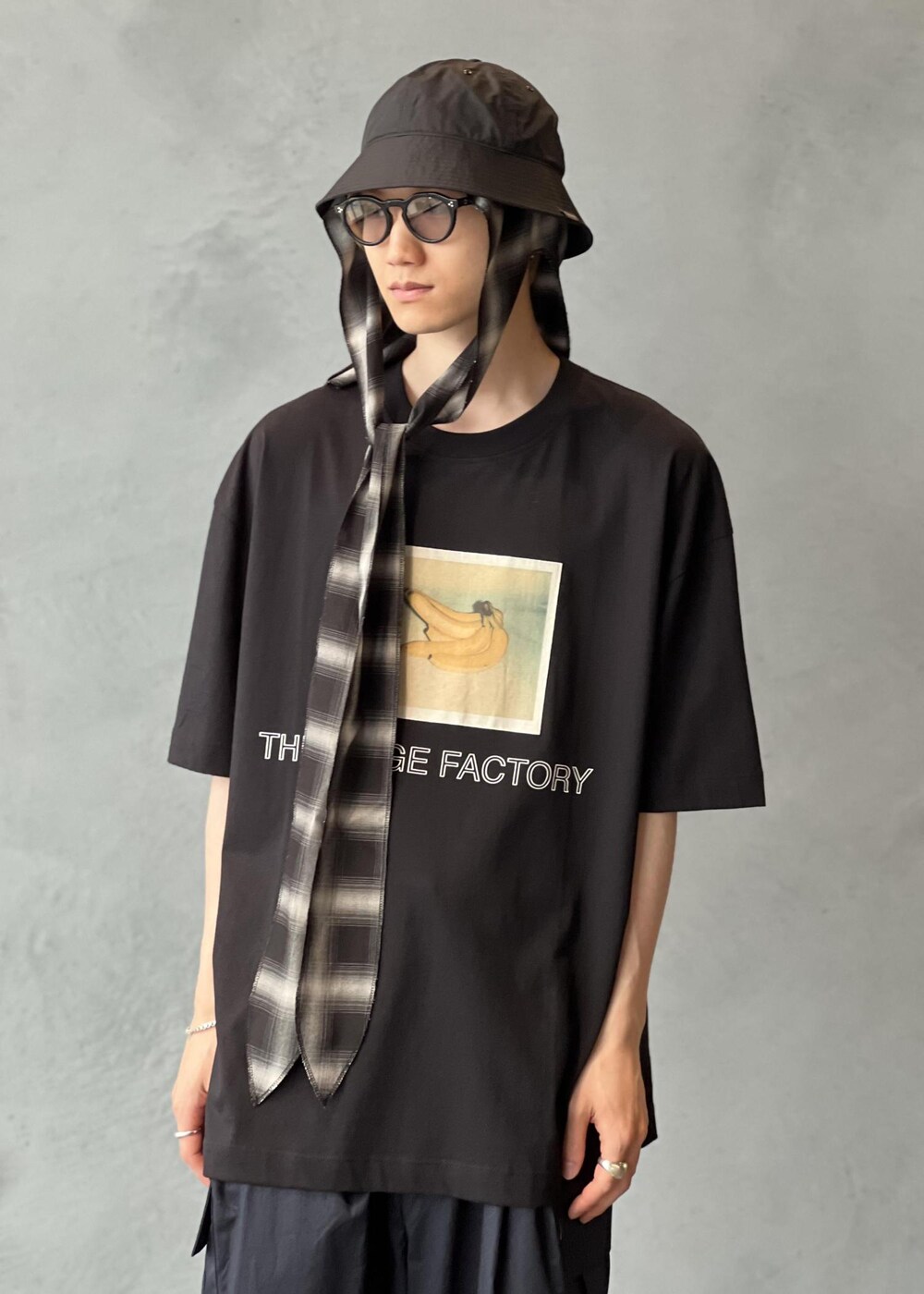 ブルー系のスラックス、ブラック系のTシャツ/カットソー、ブラック系のサングラスを着用したメンズの夏コーディネートの4枚目の写真