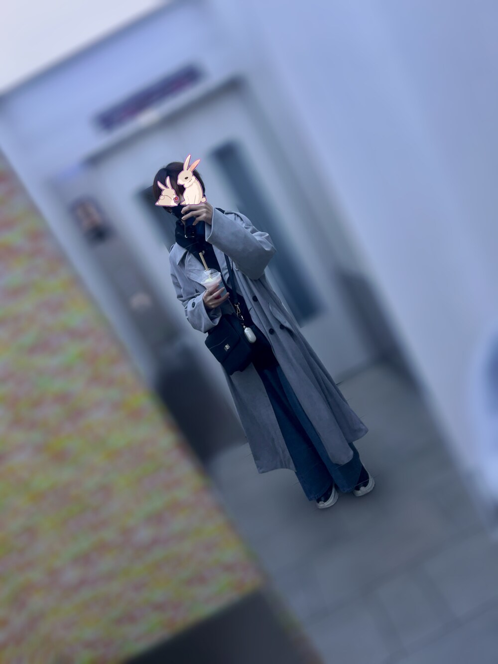 ブラック系のショルダーバッグ、グレー系のトレンチコート、ブラック系のパーカーを着用したメンズの秋コーディネートの2枚目の写真