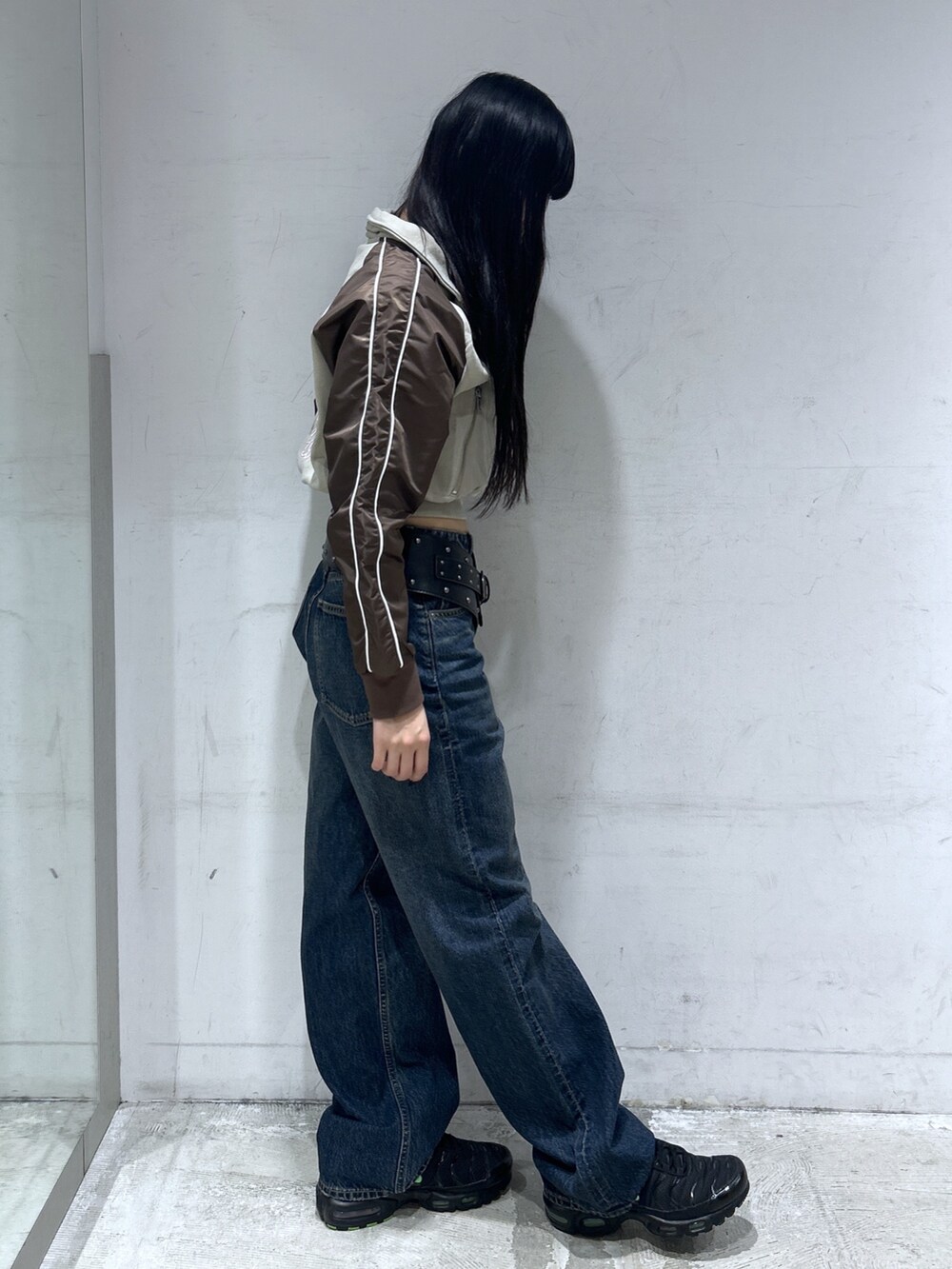 ベージュ系のスウェット、ブルー系のデニムパンツ、ブラック系のベルトを着用したレディースの春コーディネートの2枚目の写真
