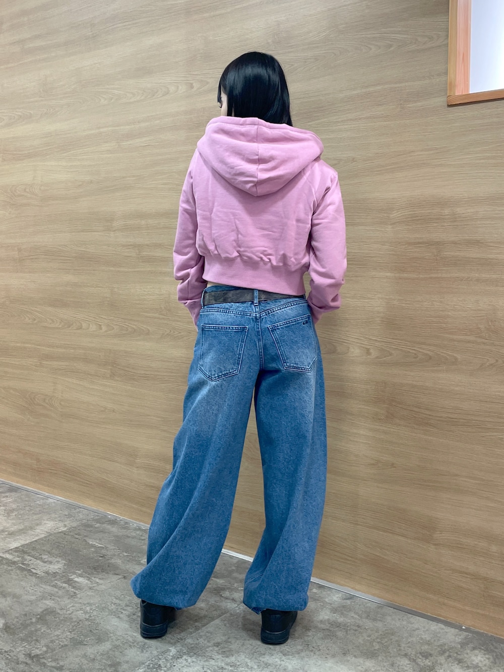 ブラック系のタンクトップ、ピンク系のパーカー、ブルー系のデニムパンツを着用したレディースの秋コーディネートの4枚目の写真