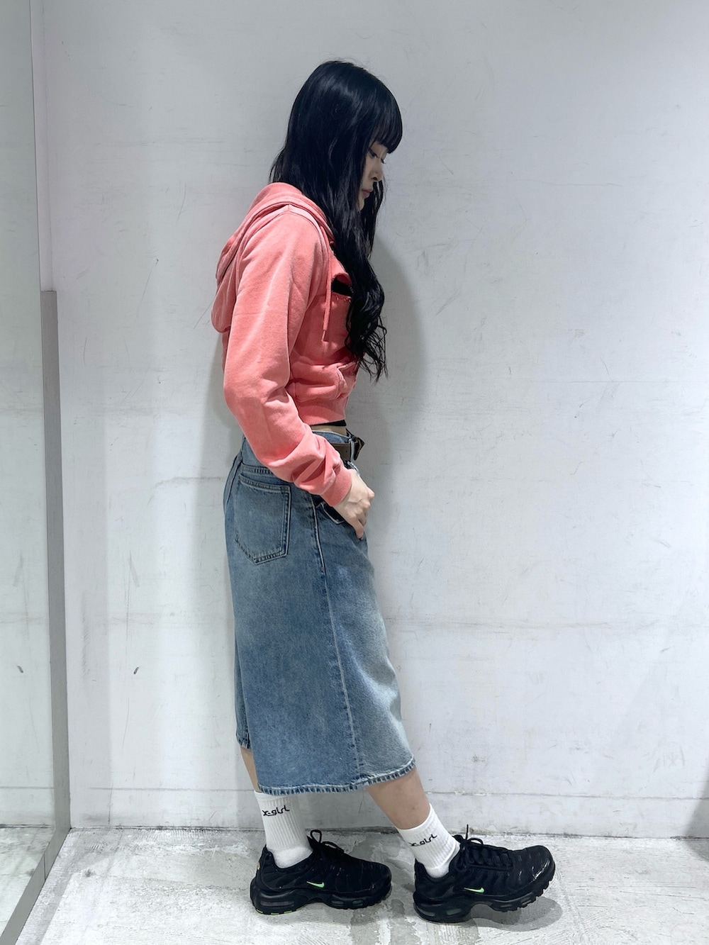 ブルー系のデニムパンツ、オレンジ系のパーカー、ブラック系のTシャツ/カットソーを着用したレディースの春コーディネートの2枚目の写真