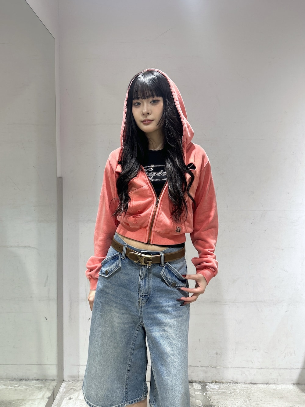 ブルー系のデニムパンツ、オレンジ系のパーカー、ブラック系のTシャツ/カットソーを着用したレディースの春コーディネートの4枚目の写真