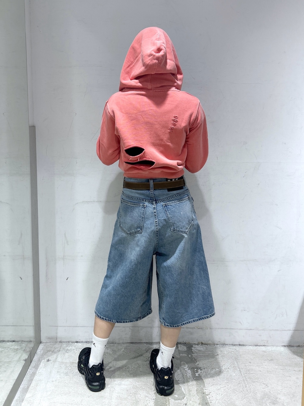 ブルー系のデニムパンツ、オレンジ系のパーカー、ブラック系のTシャツ/カットソーを着用したレディースの春コーディネートの3枚目の写真