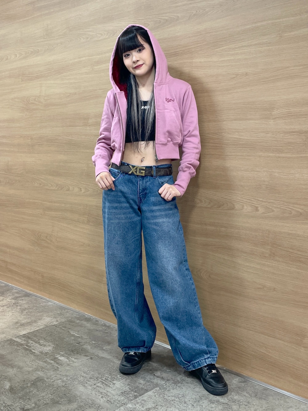 ブラック系のタンクトップ、ピンク系のパーカー、ブルー系のデニムパンツを着用したレディースの秋コーディネートの2枚目の写真