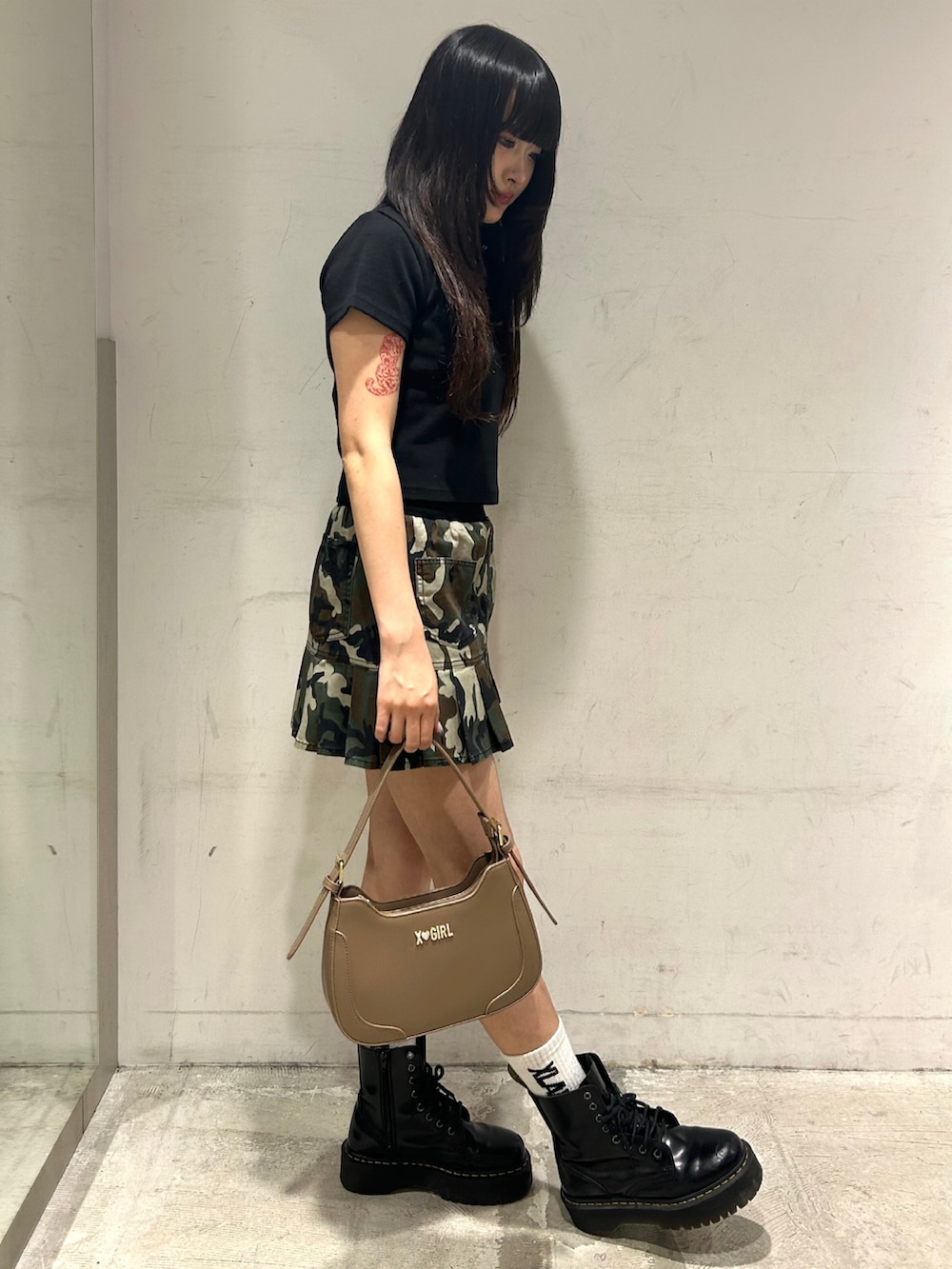 ベージュ系のハンドバッグ、その他のスカート、ブラック系のポロシャツを着用したレディースの夏コーディネートの2枚目の写真