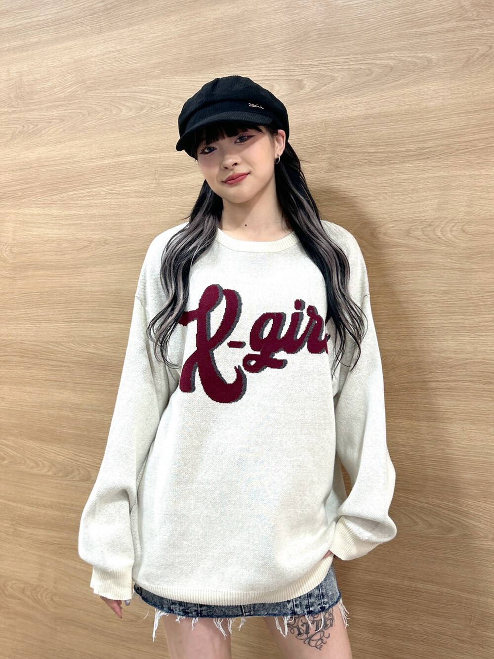 ホワイト系のニット/セーター、ブルー系のデニムスカート、ブラック系のキャスケットを着用したレディースの秋コーディネートの4枚目の写真