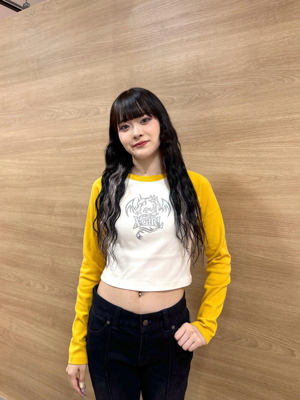 ブラック系のデニムパンツ、イエロー系のTシャツ/カットソー、グレー系のボディバッグ/ウエストポーチを着用したレディースの秋コーディネートの4枚目の写真