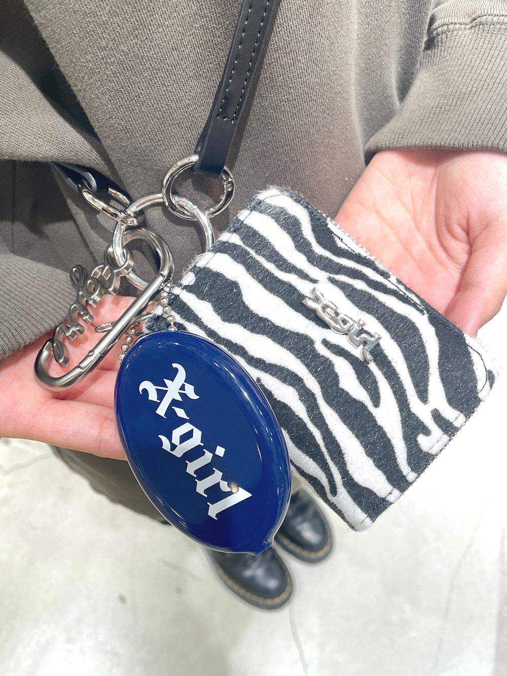 グリーン系のパーカー、ブラック系のスカート、ホワイト系のコインケースを着用したレディースの秋コーディネートの5枚目の写真