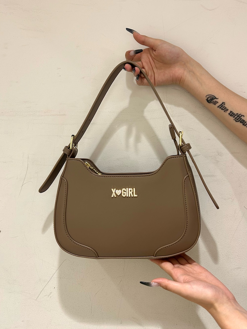 ベージュ系のハンドバッグ、その他のスカート、ブラック系のポロシャツを着用したレディースの夏コーディネートの5枚目の写真