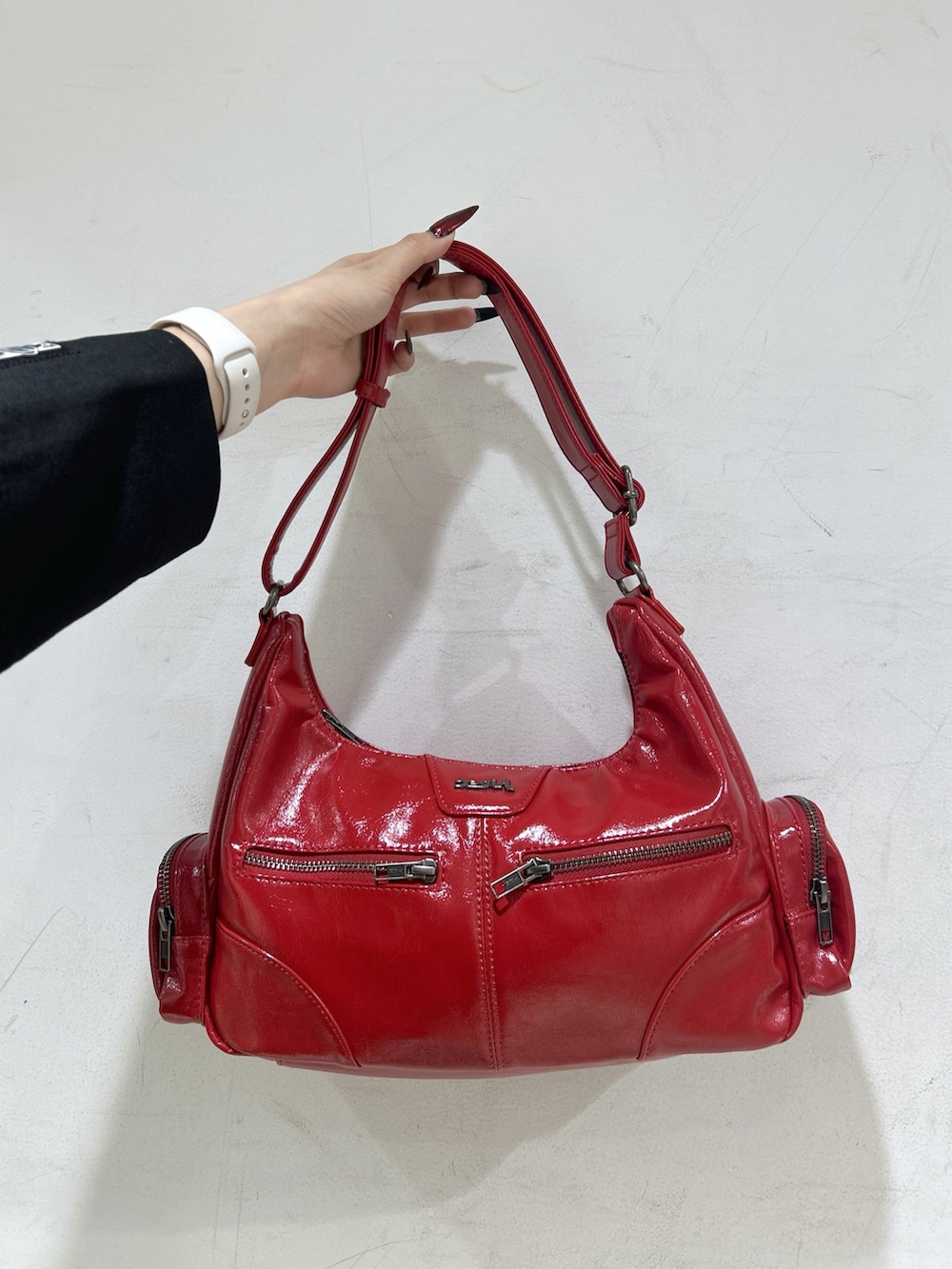 レッド系のショルダーバッグ、ブラック系のテーラードジャケット、ホワイト系のTシャツ/カットソーを着用したレディースの春コーディネートの5枚目の写真