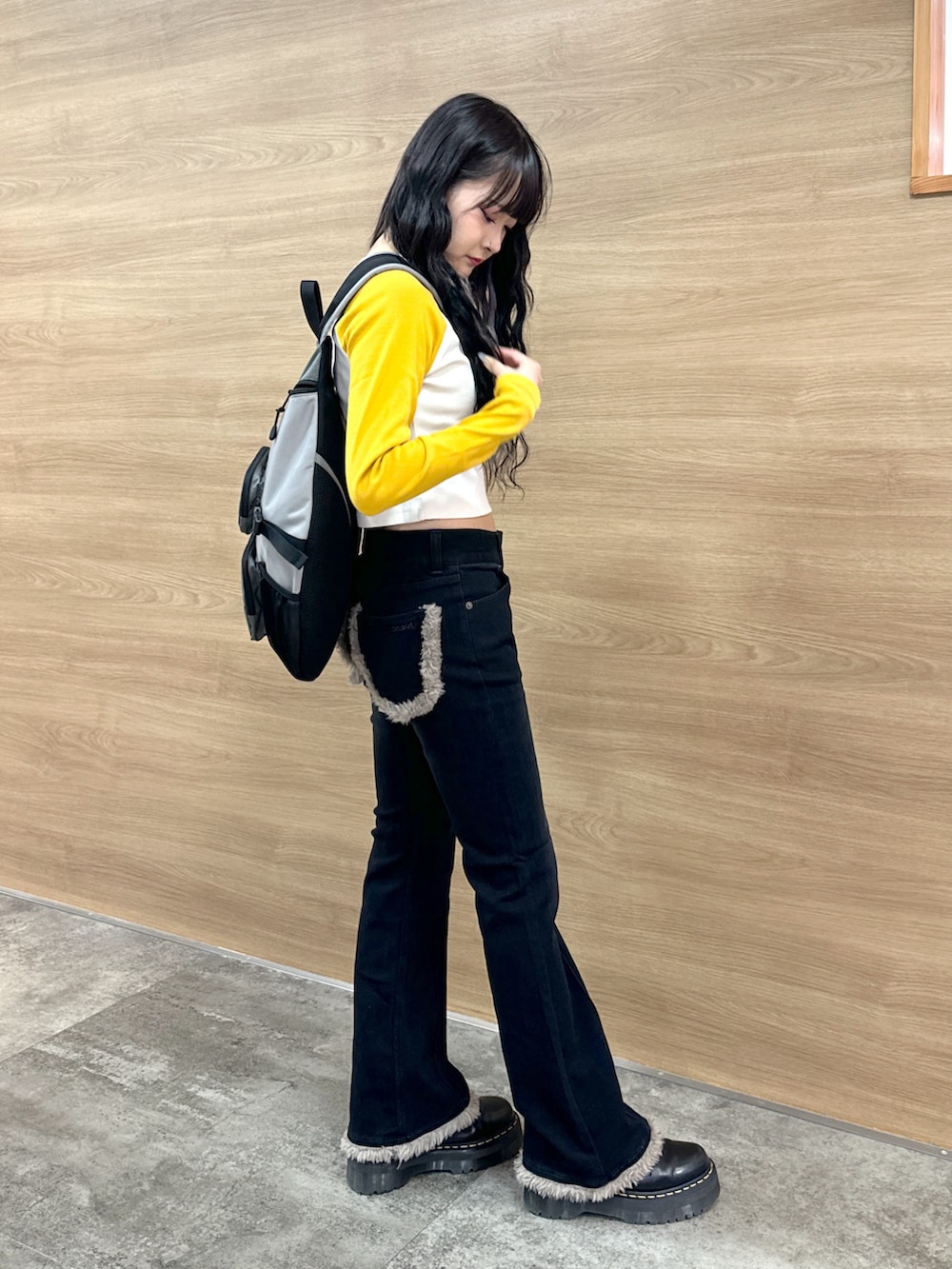 ブラック系のデニムパンツ、イエロー系のTシャツ/カットソー、グレー系のボディバッグ/ウエストポーチを着用したレディースの秋コーディネートの2枚目の写真