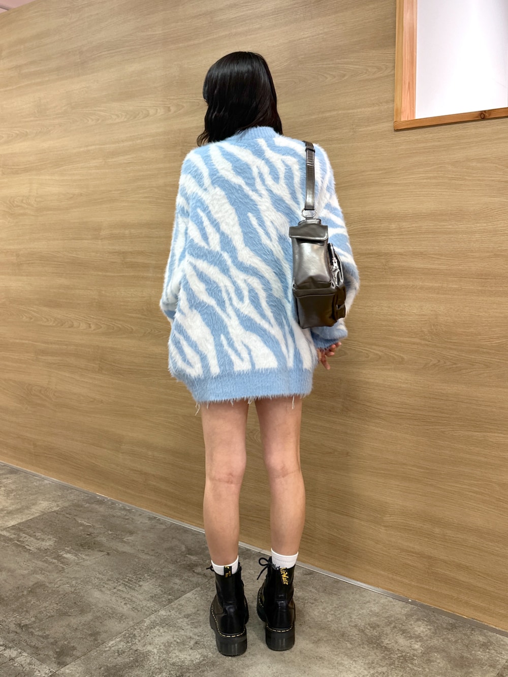 ブルー系のカーディガン/ボレロ、ブルー系のデニムスカート、グレー系のハンドバッグを着用したレディースの秋コーディネートの3枚目の写真