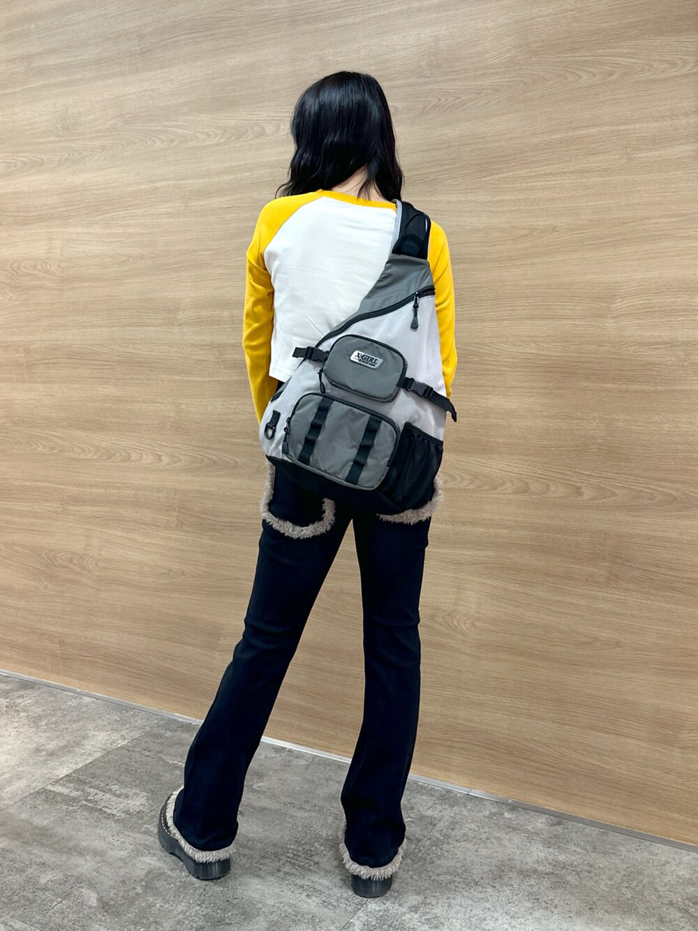 ブラック系のデニムパンツ、イエロー系のTシャツ/カットソー、グレー系のボディバッグ/ウエストポーチを着用したレディースの秋コーディネートの3枚目の写真