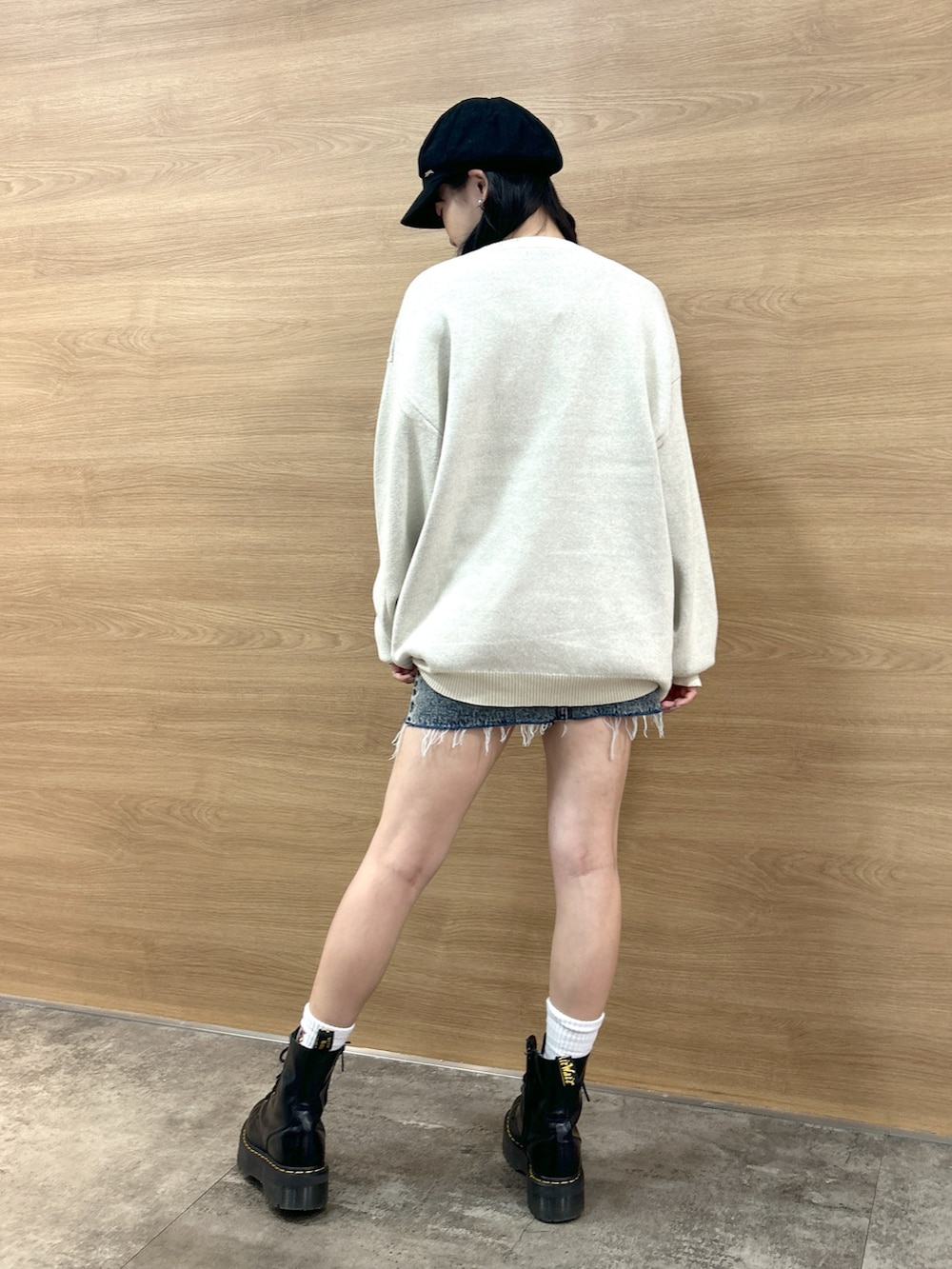 ホワイト系のニット/セーター、ブルー系のデニムスカート、ブラック系のキャスケットを着用したレディースの秋コーディネートの3枚目の写真