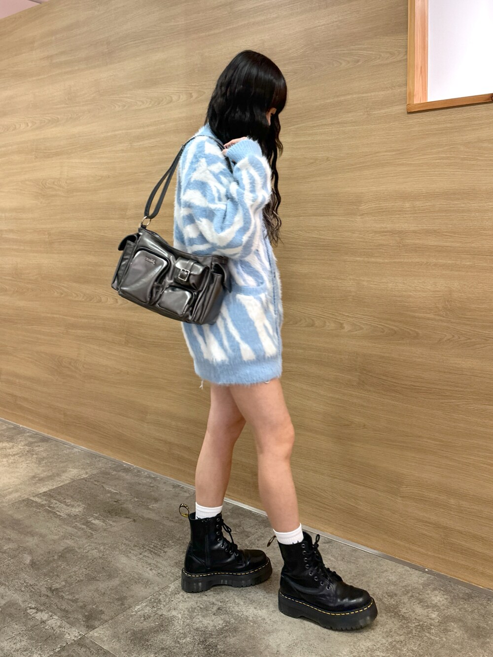 ブルー系のカーディガン/ボレロ、ブルー系のデニムスカート、グレー系のハンドバッグを着用したレディースの秋コーディネートの2枚目の写真