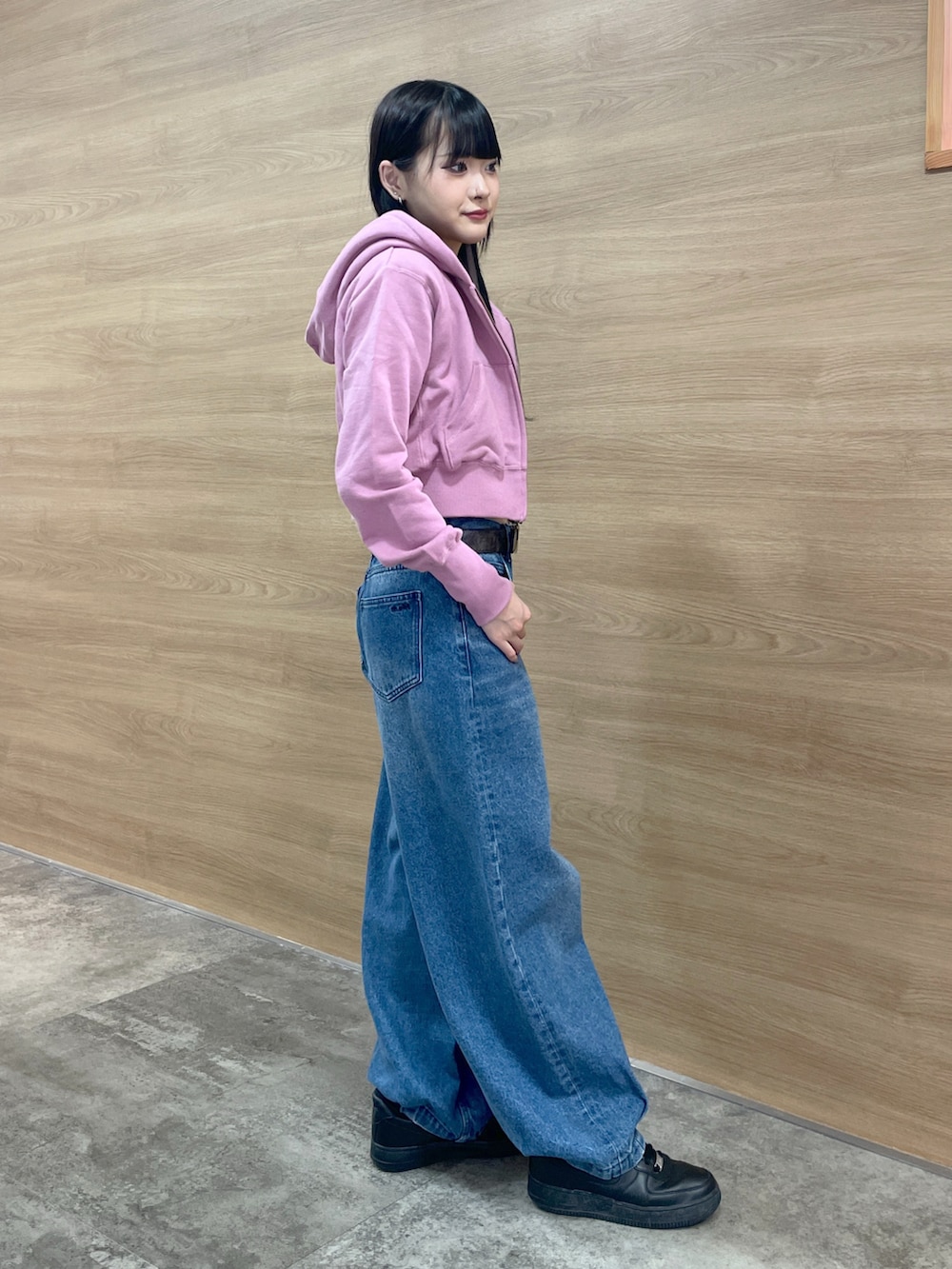 ブラック系のタンクトップ、ピンク系のパーカー、ブルー系のデニムパンツを着用したレディースの秋コーディネートの3枚目の写真