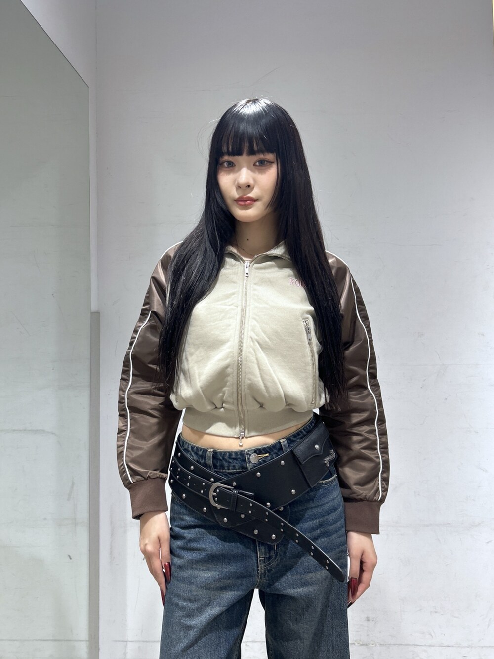 ベージュ系のスウェット、ブルー系のデニムパンツ、ブラック系のベルトを着用したレディースの春コーディネートの4枚目の写真