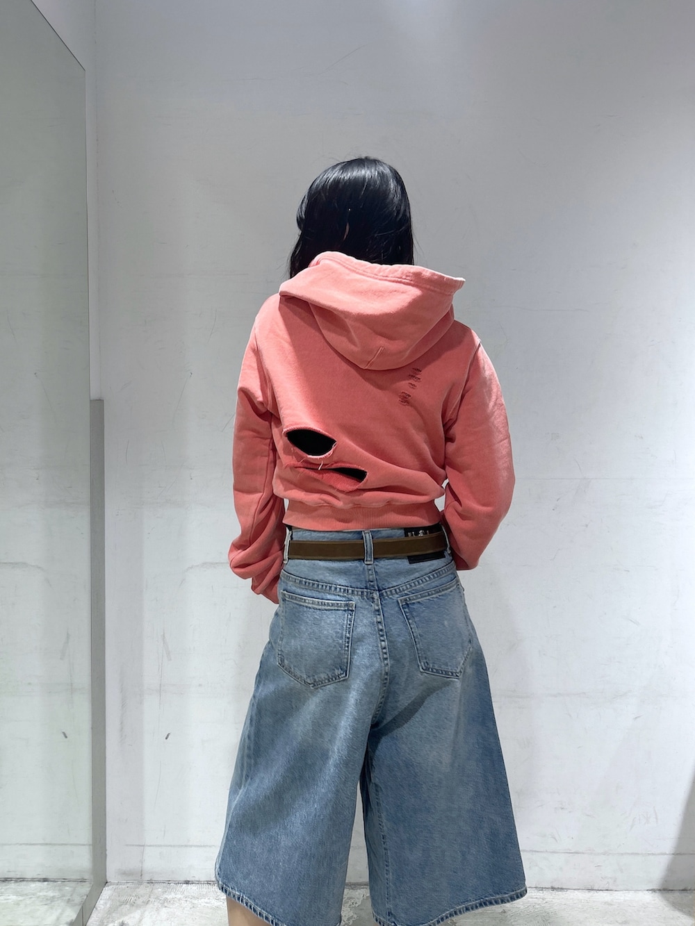 ブルー系のデニムパンツ、オレンジ系のパーカー、ブラック系のTシャツ/カットソーを着用したレディースの春コーディネートの5枚目の写真