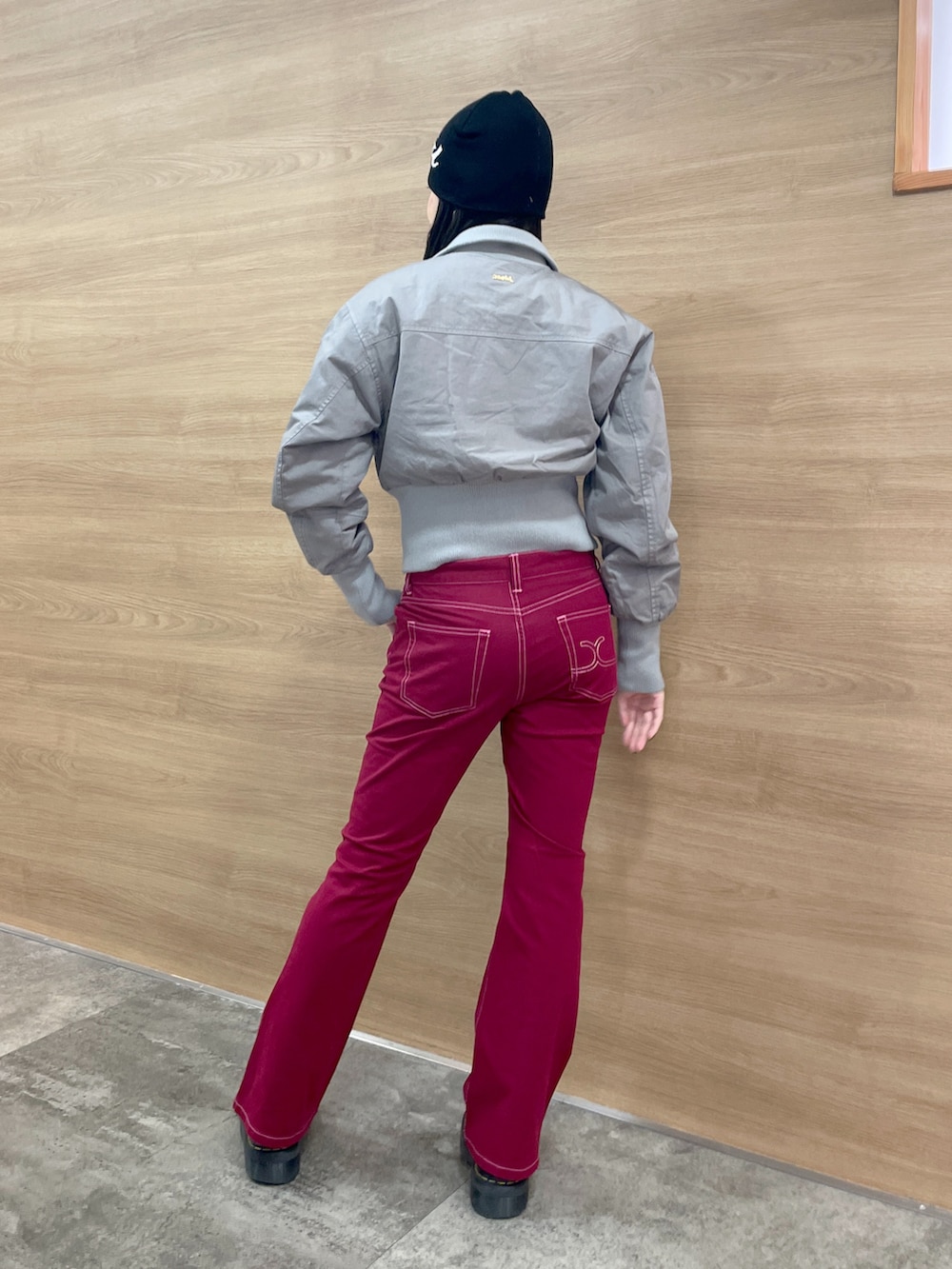 レッド系のその他パンツ、グレー系のブルゾン、ブラック系のニットキャップ/ビーニーを着用したレディースの秋コーディネートの3枚目の写真