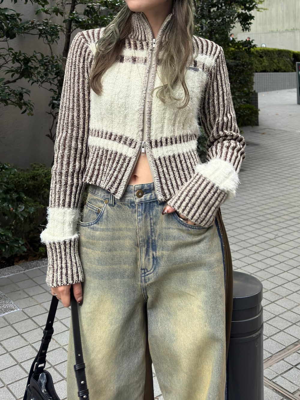ホワイト系のニット/セーター、ブルー系のデニムパンツ、ブラック系のショルダーバッグを着用したレディースの秋コーディネートの2枚目の写真