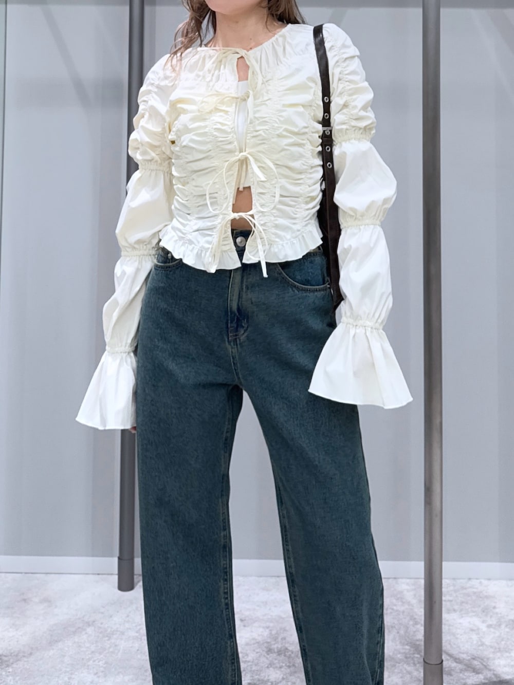 ホワイト系のシャツ/ブラウス、ブルー系のデニムパンツ、ブラック系のパンプスを着用したレディースの冬コーディネートの3枚目の写真