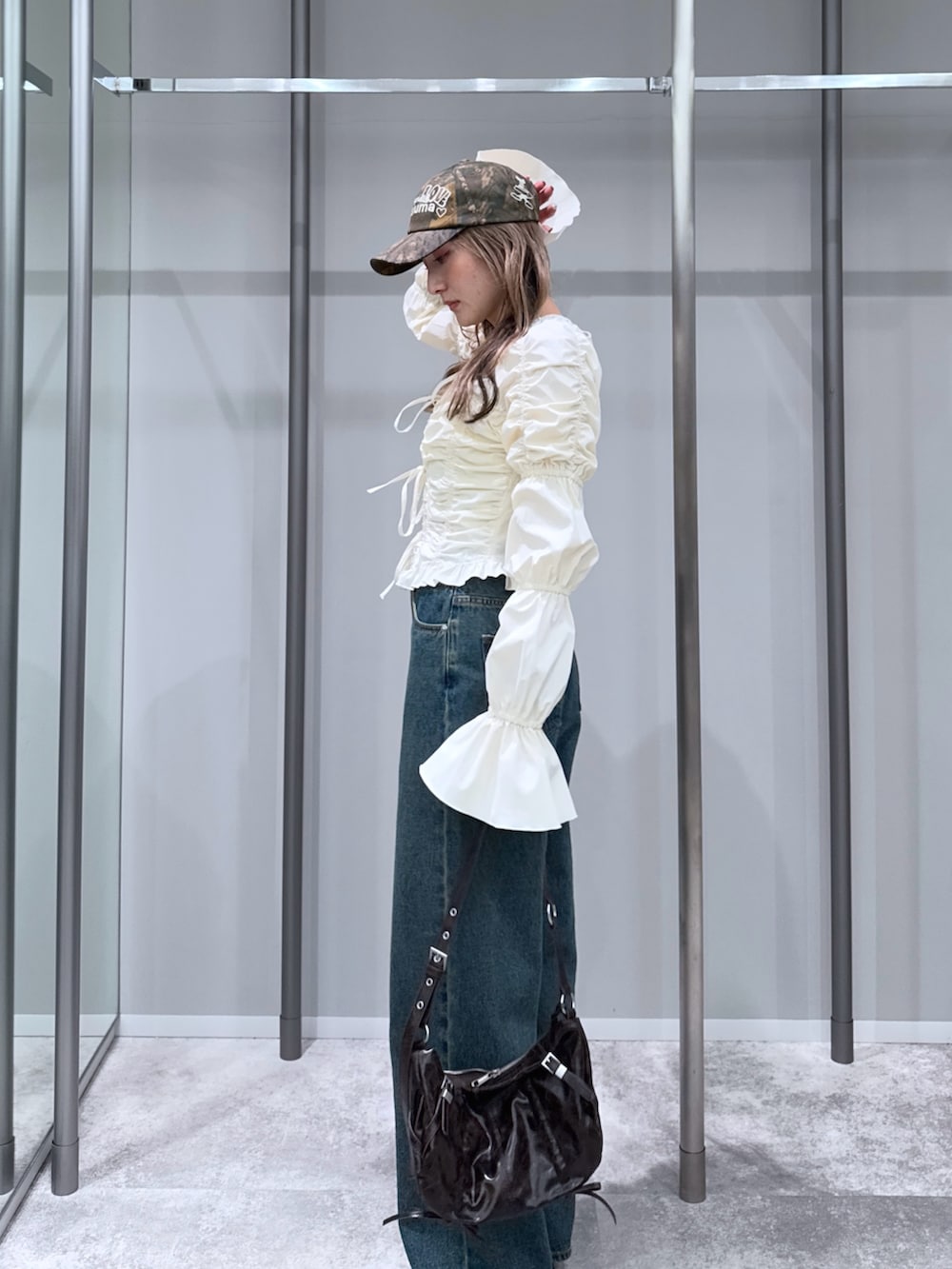 ホワイト系のシャツ/ブラウス、ブルー系のデニムパンツ、ブラック系のパンプスを着用したレディースの冬コーディネートの2枚目の写真