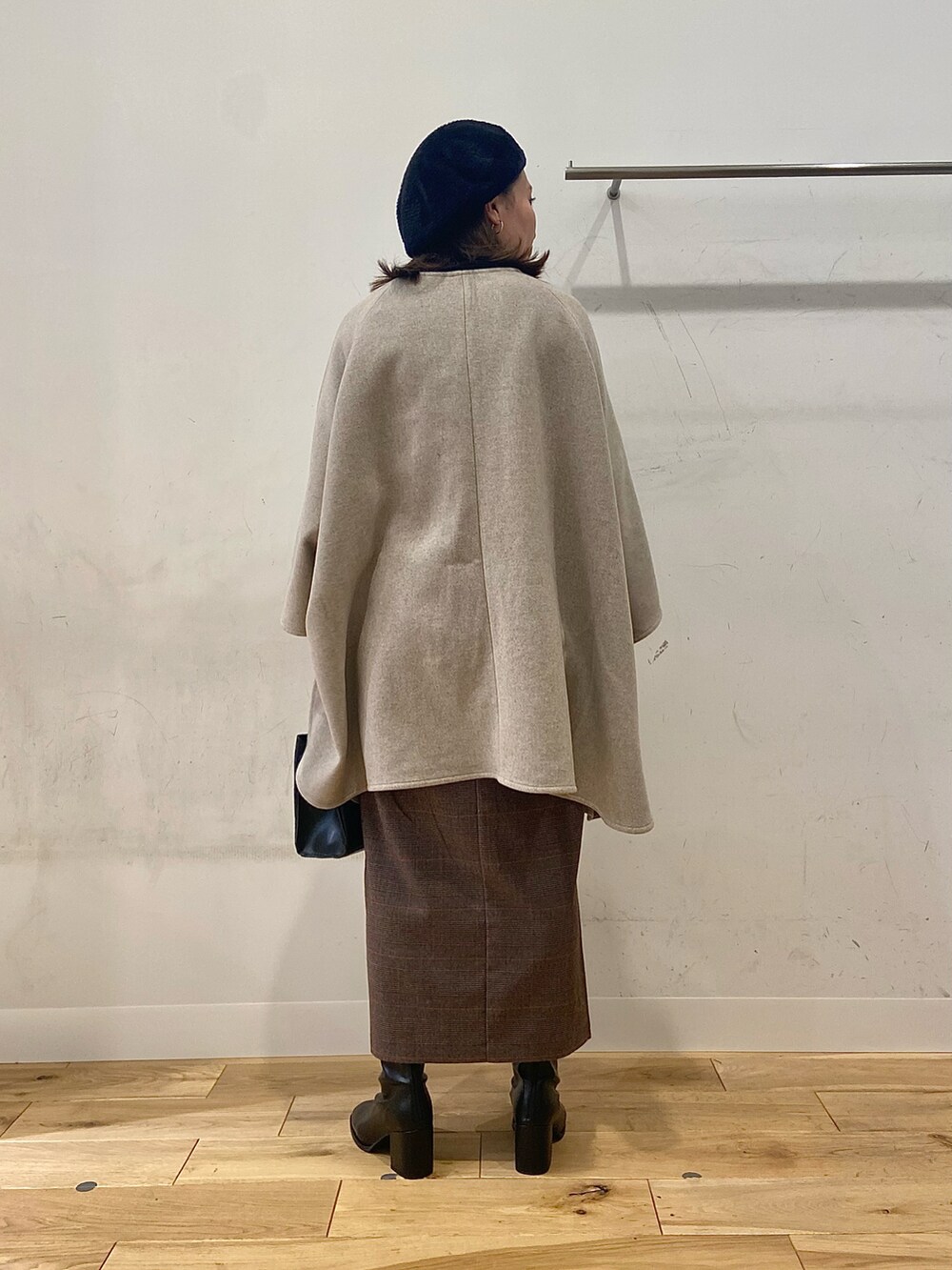 ブラック系のブーツ、ブラウン系のスカート、ブラック系のショルダーバッグを着用したレディースの冬コーディネートの4枚目の写真