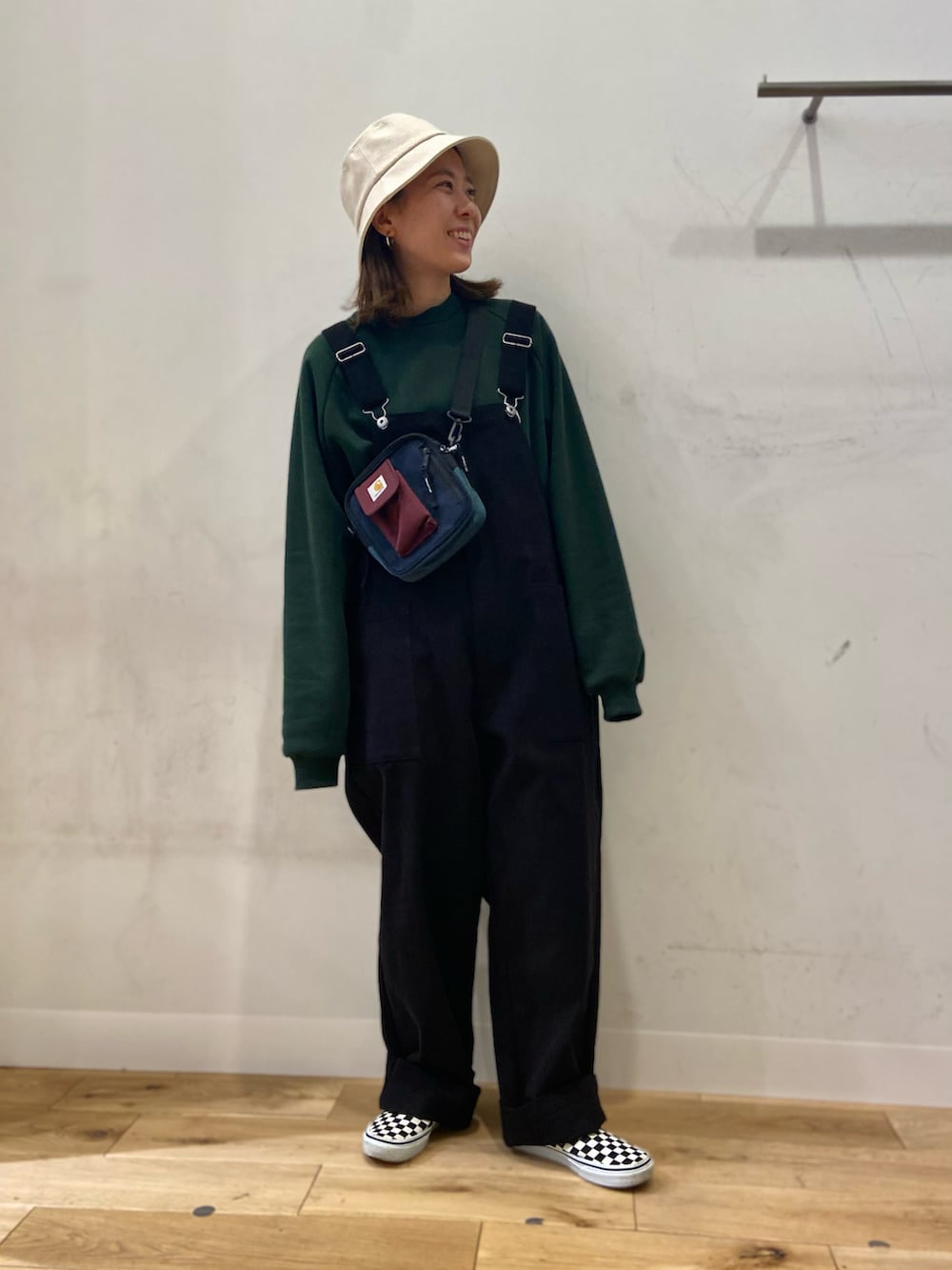 グリーン系のスウェット、ブラック系のサロペット/オーバーオール、その他のショルダーバッグを着用したレディースの冬コーディネートの3枚目の写真