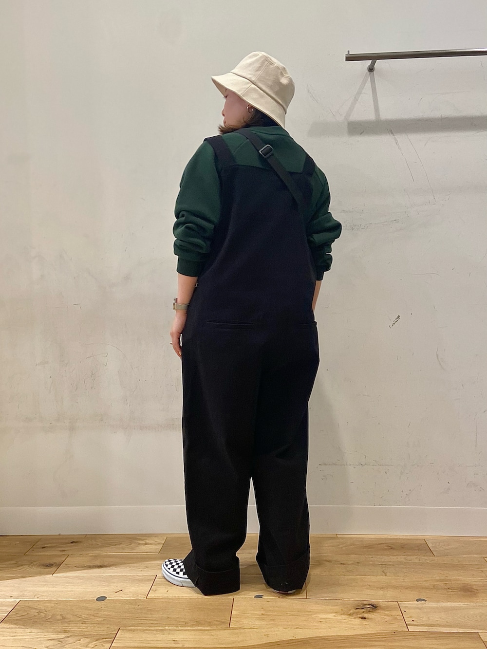 グリーン系のスウェット、ブラック系のサロペット/オーバーオール、その他のショルダーバッグを着用したレディースの冬コーディネートの2枚目の写真