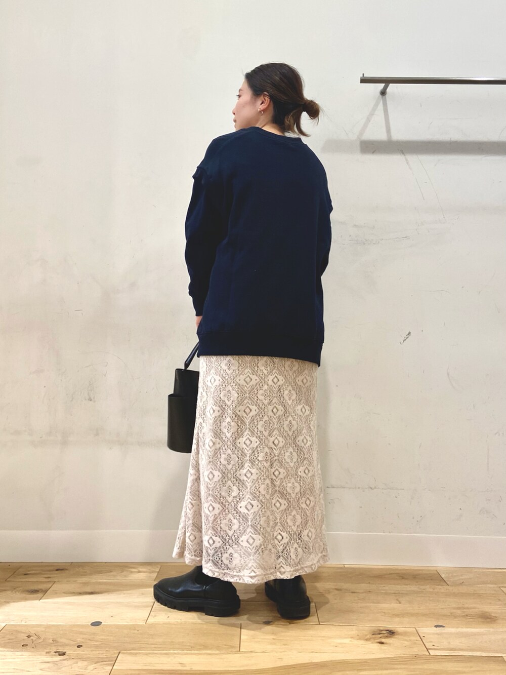 ブラック系のトートバッグ、ブラック系のブーツ、ブルー系のスウェットを着用したレディースの冬コーディネートの2枚目の写真