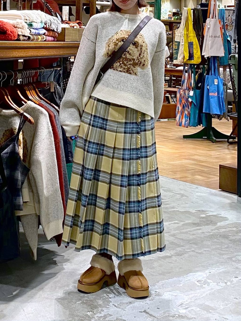 ベージュ系のスカート、イエロー系のブーツ、ブラウン系のショルダーバッグを着用したレディースの秋コーディネートの4枚目の写真