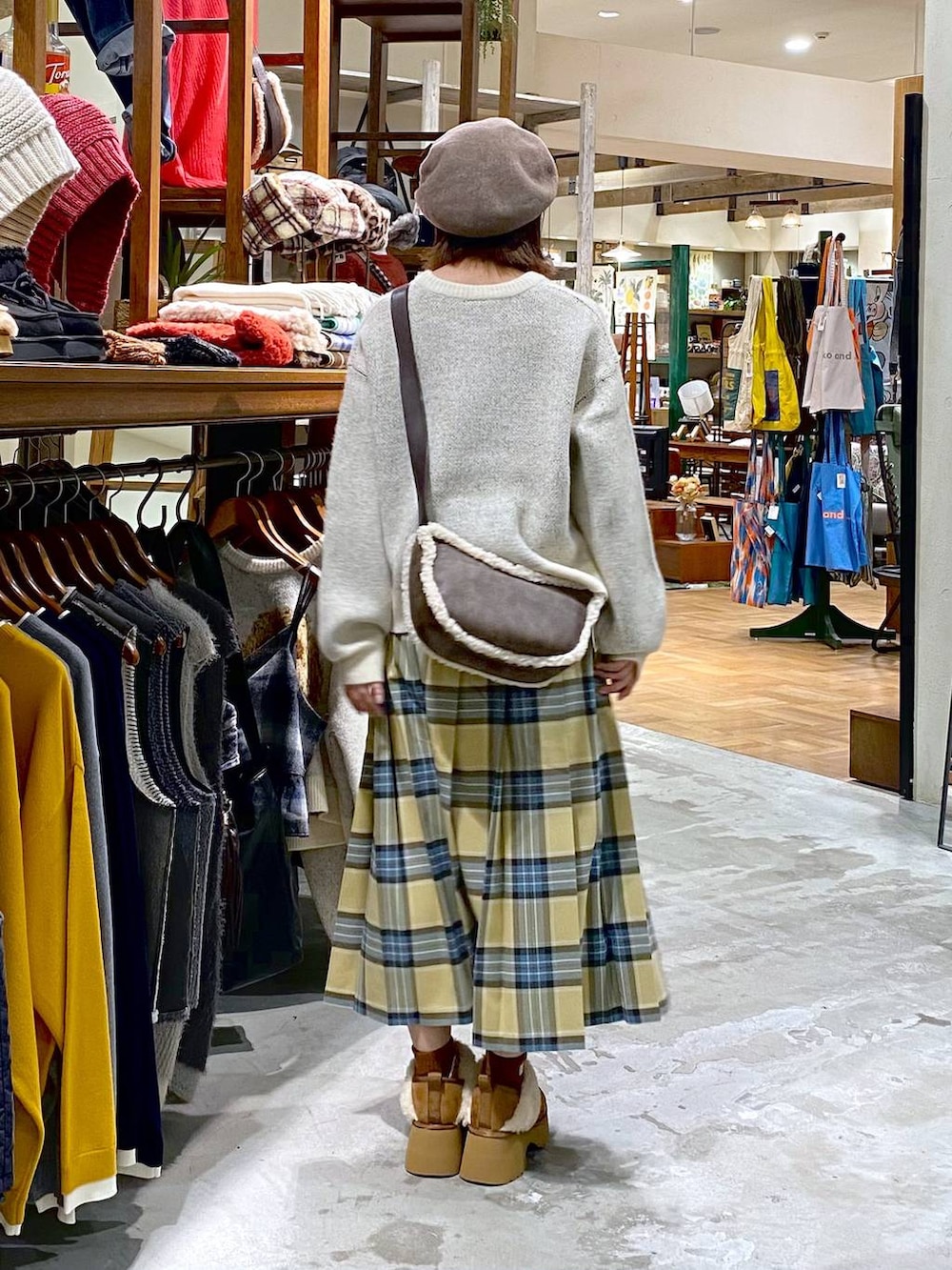 ベージュ系のスカート、イエロー系のブーツ、ブラウン系のショルダーバッグを着用したレディースの秋コーディネートの3枚目の写真