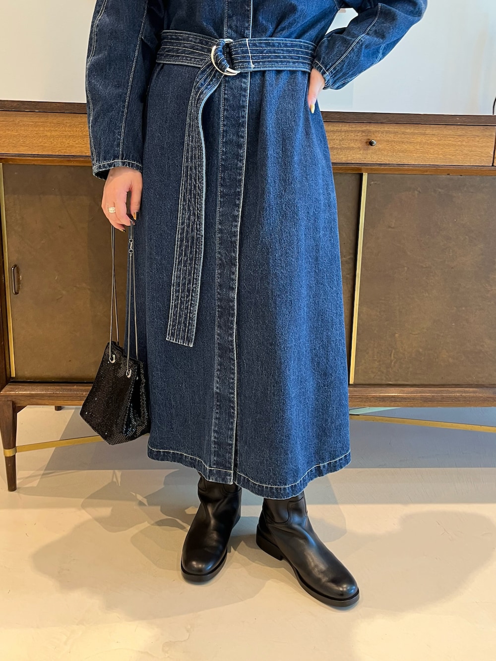 ブルー系のノーカラーコート、ブラック系のトートバッグ、ブラック系のブーツを着用したレディースの夏コーディネートの3枚目の写真