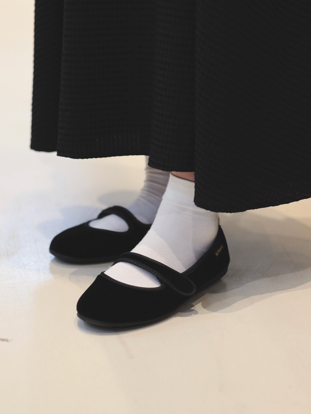 ホワイト系のブルゾン、ブラック系のワンピース、レッド系のショルダーバッグを着用したレディースの夏コーディネートの3枚目の写真