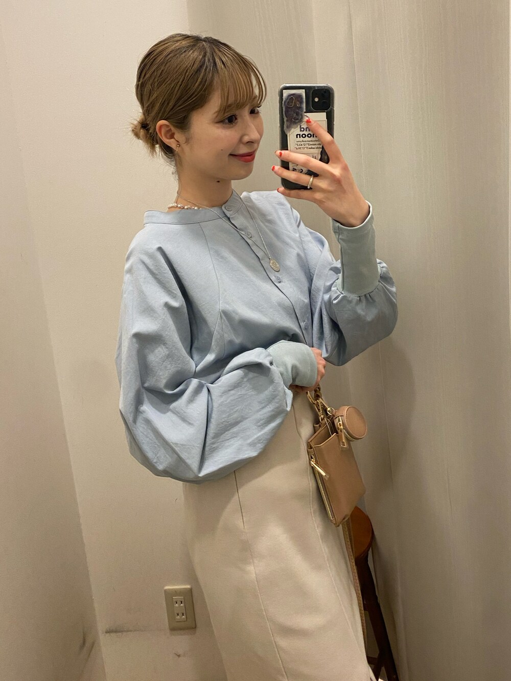 ブルー系のシャツ/ブラウス、ベージュ系のスカート、ベージュ系のショルダーバッグを着用したレディースの冬コーディネートの3枚目の写真